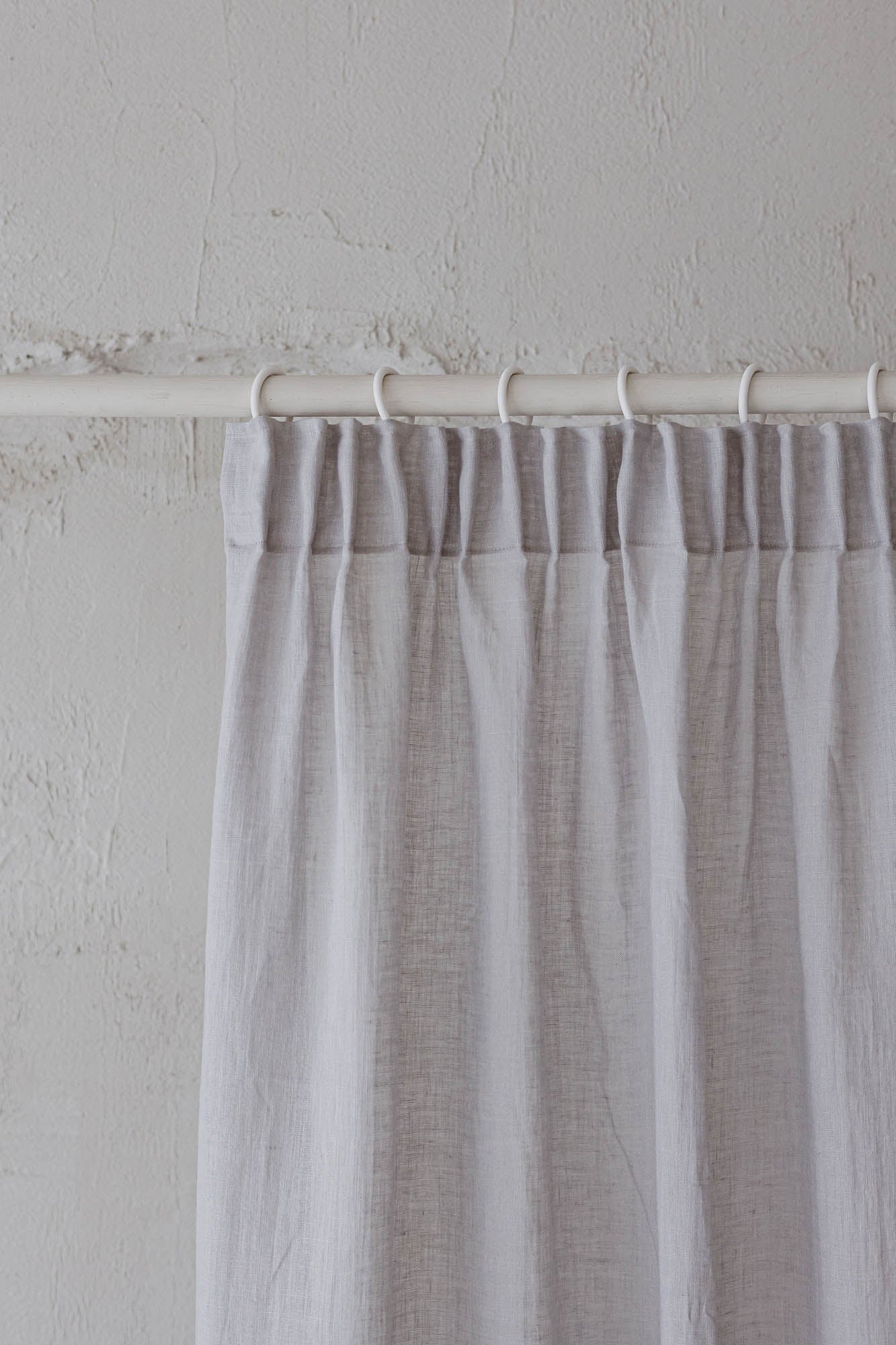 Transparenter Leinenvorhang mit Bleistiftfalten an einem regnerischen Tag