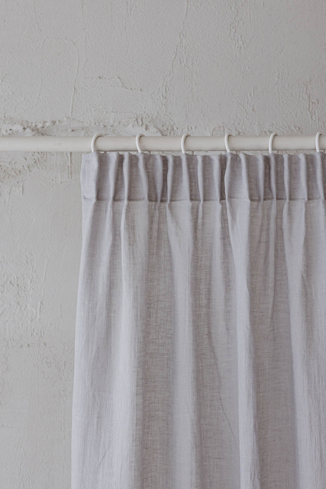 Transparenter Leinenvorhang mit Bleistiftfalten an einem regnerischen Tag