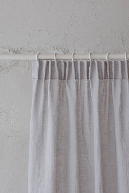 Transparenter Leinenvorhang mit Bleistiftfalten an einem regnerischen Tag