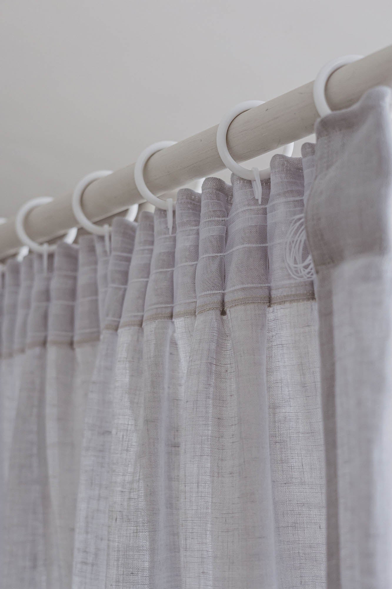 Transparenter Leinenvorhang mit Bleistiftfalten an einem regnerischen Tag